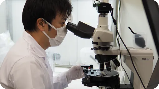 顕微鏡をのぞく技術者
