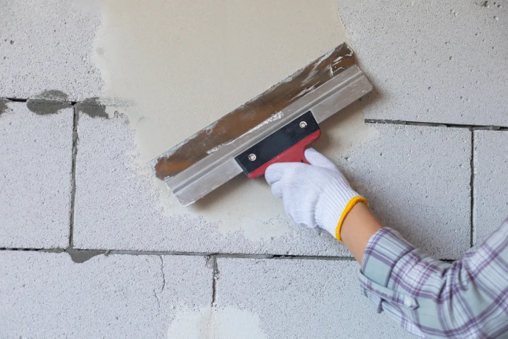 The-master-levels-the-wall-with-a-spatula