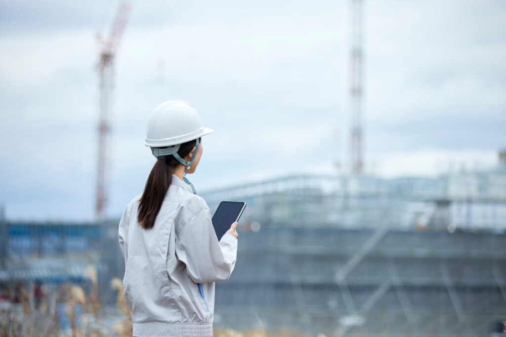 建設現場と作業服を着た女性