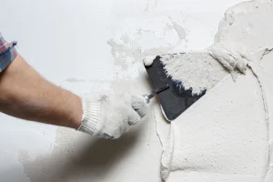 左官ごてで壁を塗っている建設作業員