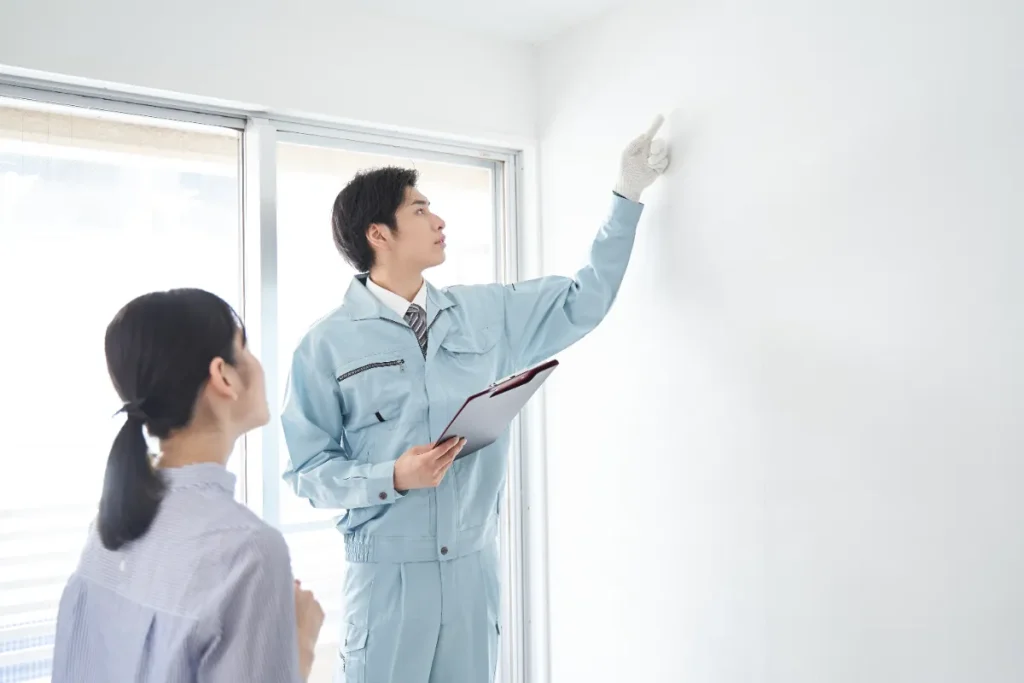 部屋の設備チェックをする日本人男性作業員 