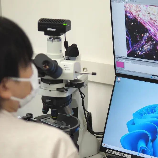 顕微鏡を用いてアスベスト分析を行う様子