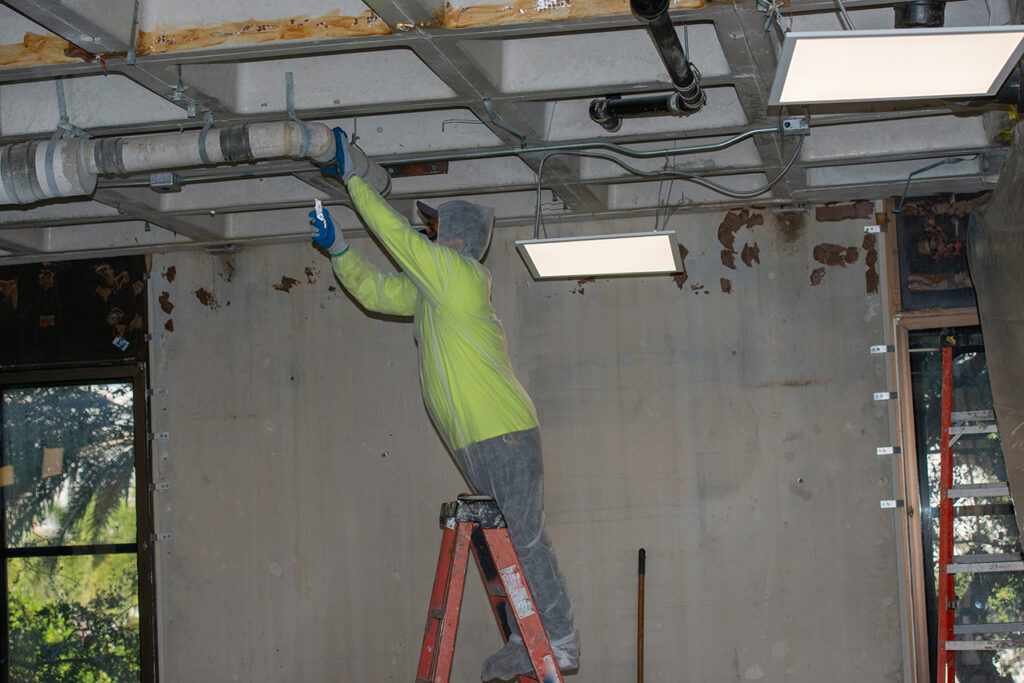 作業員が、慎重に古い排水管の撤去作業をしている